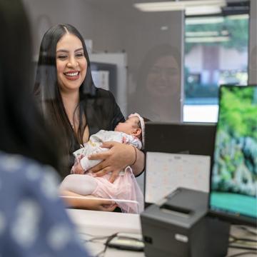 woman at credit union branch holding baby
