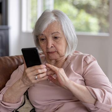 elderly person looking at telephone